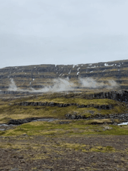 Tourist documents Icelandic waterfall and mountain landscape
