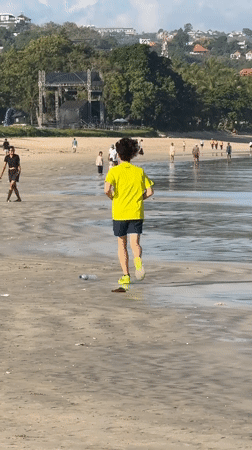 Early morning beach activities in Kuta: jogger, boat launches