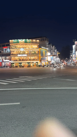 Busy nighttime street scene captured near Da Lat coffee shop