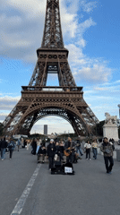 Band performs near Eiffel Tower as crowds gather