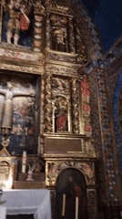 Inside a historic stone Catholic church, altars and sacred art