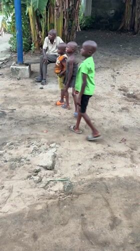 Children and elderly man gather in Ikot Ekpene yard