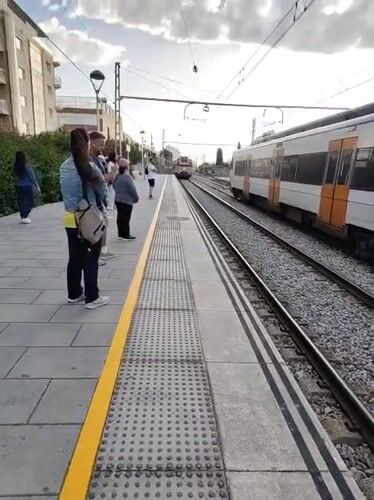 Morning trains serve passengers at Calella station platform