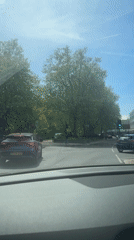 Vehicle waits at London intersection, passes Thai establishment