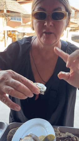 Woman enjoys fresh seafood at Thai coastal market