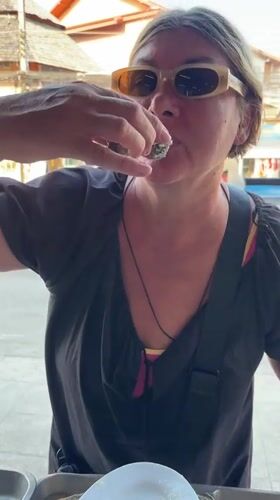 Woman enjoys fresh seafood at Thai coastal market