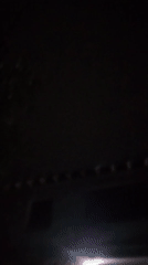Dark, grainy nighttime footage outside buildings in Kuyoshli, Uzbekistan