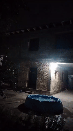 Dark, grainy nighttime footage outside buildings in Kuyoshli, Uzbekistan