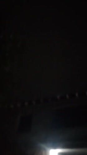 Dark, grainy nighttime footage outside buildings in Kuyoshli, Uzbekistan