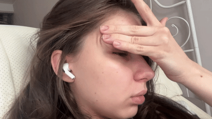 Woman with AirPod recorded covering face indoors in Saint Petersburg