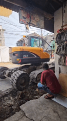 Street excavation crew digs trench and loads dump truck in Denpasar