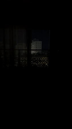 Nighttime cityscape viewed from apartment window in Bat Yam