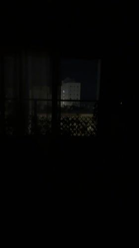 Nighttime cityscape viewed from apartment window in Bat Yam
