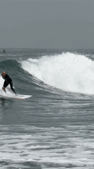Surfers ride choppy waves near Tel Aviv breakwater Saturday morning