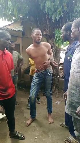 Crowd gathers around restrained man on Kaduna South street