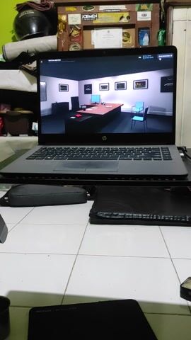 Here is a description of the scene in the video:

The scene shows a laptop with a soccer game or tactical analysis displayed on the screen. The laptop is positioned horizontally on a surface with white tiles, possibly the floor. To the left of the laptop, there is a cluttered shelf or storage area with various items, including bottles, boxes, a helmet, and a certificate. The laptop is open and operational, showing detailed information about the game, players, and tactical formations. There are also additional items to the right of the laptop, including what appears to be a laptop bag and a mousepad.