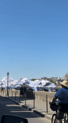 Cyclist spotted on sunny Paris street near river