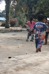 Kids playing and making kites in a rural Indonesian courtyard