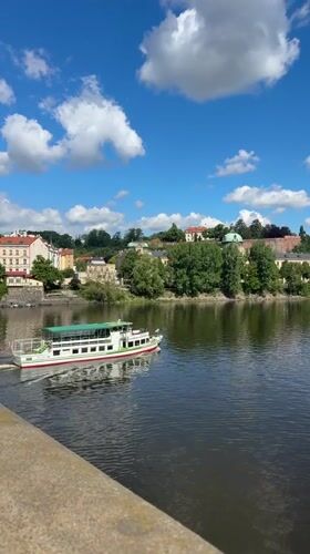 Tourist captures Prague riverfront and castle views during morning walk