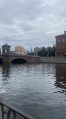 Domed stone bridge spans a dark Saint Petersburg canal