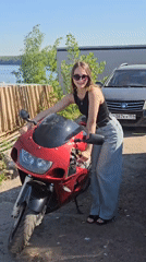 Woman poses with red motorcycle in Chaikovsky, Russia