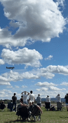 Propeller plane drifts across a cloud-filled sky over Cheb