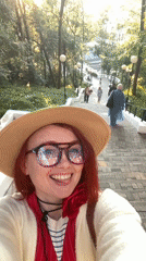 Woman takes selfies in Sochi park during golden hour