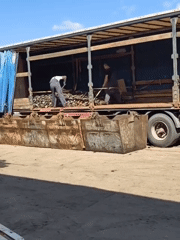 Workers unload truck materials into containers in Noviy