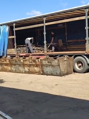 Workers unload truck materials into containers in Noviy