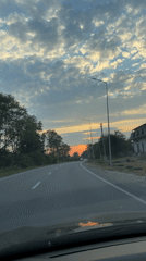 Driving through a rural sunset, golden hour on the open road