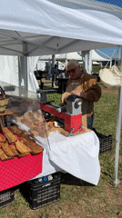 Woodworker demonstrates lathe techniques at outdoor event in Aprilia