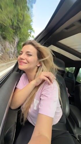Woman rides in convertible car near rocky hillside Montenegro