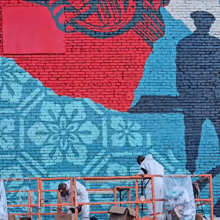 Artists paint welcome mural on Los Angeles brick wall
