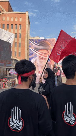 Tehran street gathering with banners and red headbands
