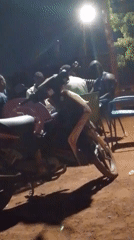 Men gather outdoors at night in Tamale, Ghana