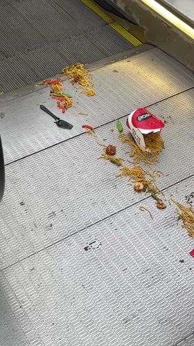Noodle container spills across Amsterdam escalator steps