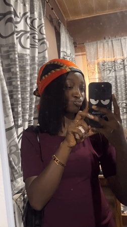 Woman takes selfies in mirror wearing headscarf in Jos