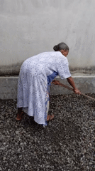 Elderly woman tends gravel work in Baron, Indonesia
