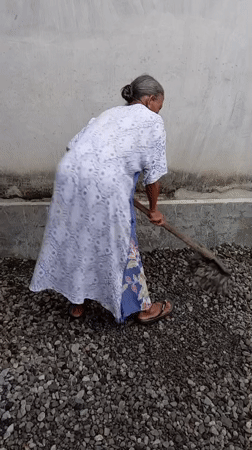 Elderly woman tends gravel work in Baron, Indonesia