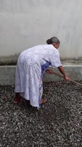 Elderly woman tends gravel work in Baron, Indonesia