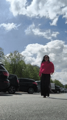 Woman in red sweater enjoys sunny morning in Riga parking lot