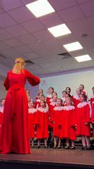 Children's choir performs in red dresses at Moscow auditorium