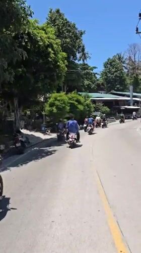 Scooter group rides through Ko Tao streets at dawn