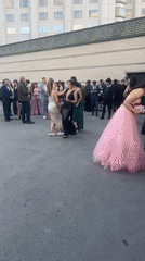 Formally dressed youth celebrate with music outside Sofia Marriott