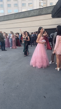 Formally dressed youth celebrate with music outside Sofia Marriott