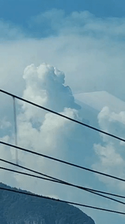 Bright daytime sky dominated by a billowing cumulus cloud