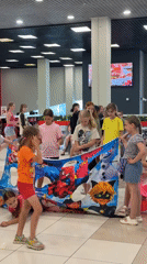 Mall character event with costumed host and kids around cartoon banner