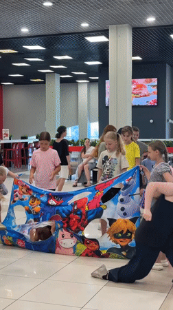 Mall character event with costumed host and kids around cartoon banner