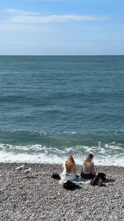 Quiet afternoon captured at Étretat beach with visitors, boats
