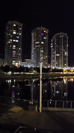 Nighttime photography session captures illuminated Kyiv waterfront and residential buildings